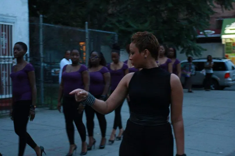 Ayesha leading a group of women in purple on a city walk at dusk