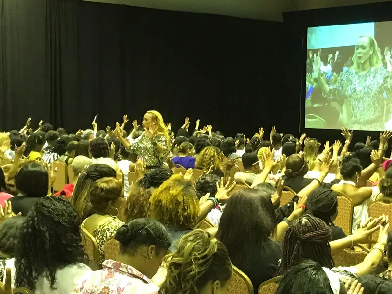Women gathered with raised hands during a live experience